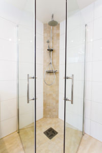 Douche italienne plain-pied avec paroi et porte
