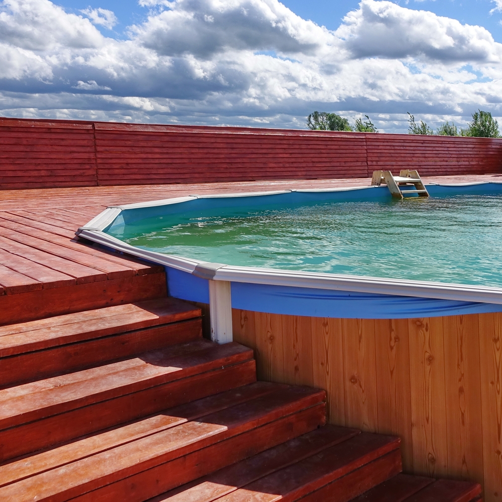 Piscine semi-enterrée avec terrasse en bois